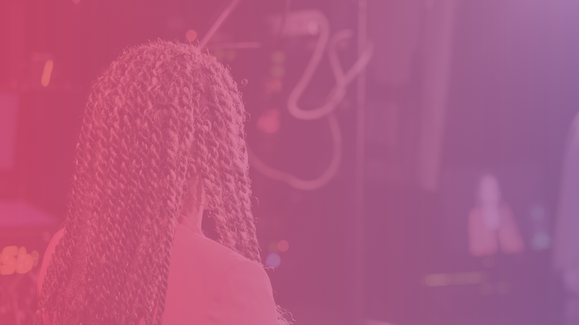 Woman sits in the spotlight at a tv studio.